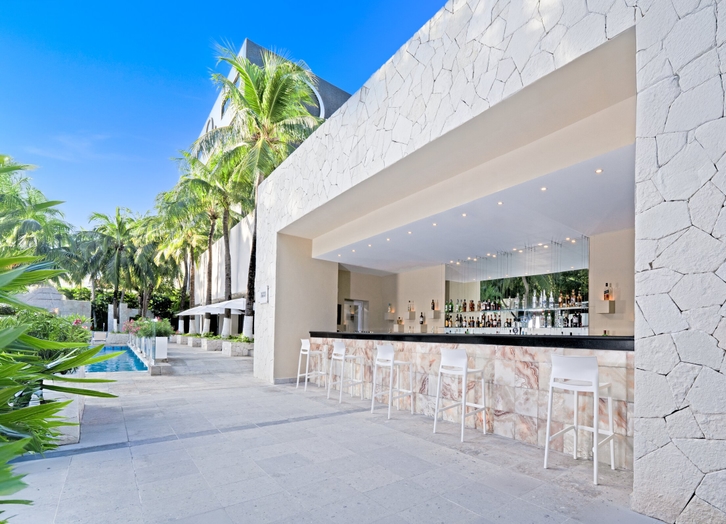 Outdoor bar with counter and stools beside the pool at Oh! Cancun