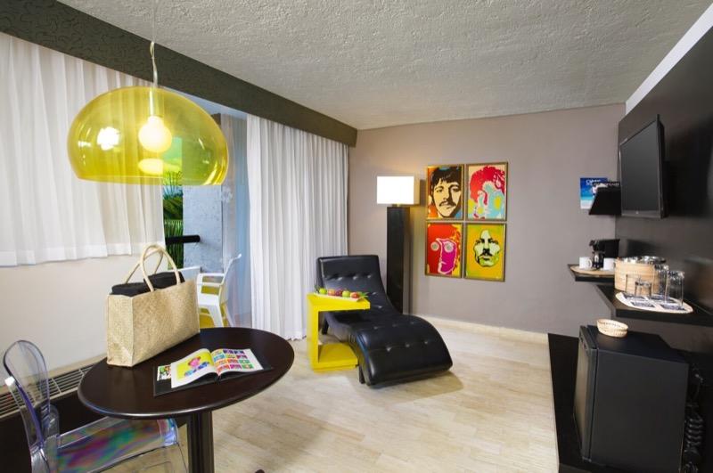 Sala tipo lounge en habitación Junior decorada con cuadros pop y balcón hotel Oh! The Urban Oasis