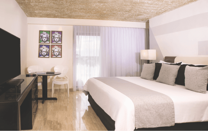 Habitación Estándar con cama King Size decorada en colores gris, rojo, negro y blanco en hotel Oh! T